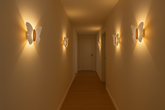 Corridor with butterfly-shaped wall lights casting a warm glow.